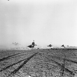 Carros de combate británicos avanzando tras la apertura de caminos en el campo minado.