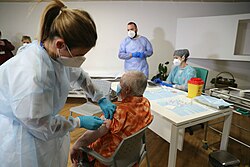 Una adulta mayor recibiendo una vacuna contra la COVID-19 en diciembre de 2020
