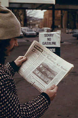 Hombre leyendo noticias sobre racionamiento de combustible en una estación de servicio en 1974
