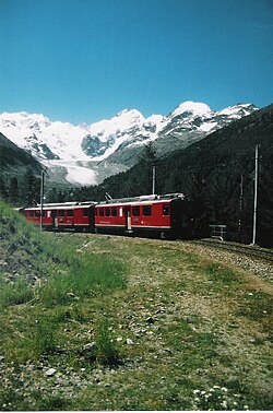Tren rojo del Ferrocarril Rético con un glaciar al fondo
