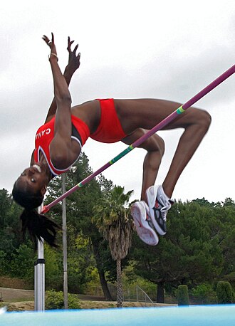 Atleta realizando un salto de altura en una competición oficial