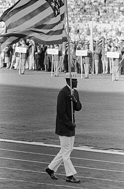 Rafer Johnson desfilando como abanderado de los Estados Unidos en la ceremonia de apertura en Roma 1960