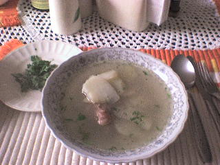 Caldo de costilla servido con papas y cilantro