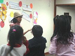 Estudiante de psicología impartiendo un taller educativo en una escuela primaria.