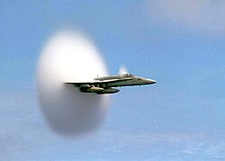 Avión militar en vuelo supersónico rompiendo la barrera del sonido