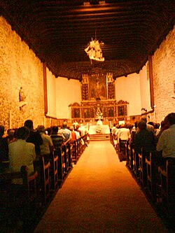 Celebración litúrgica y asistencia de fieles en el interior del Santuario de la Virgen de Arrate.