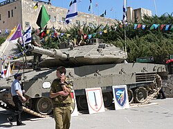 Soldados israelíes junto a un carro de combate Merkava IV