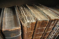 Detalle de libros antiguos encuadernados en una biblioteca.