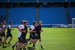 Equipo del Liverpool FC trotando juntos sobre el terreno de entrenamiento.