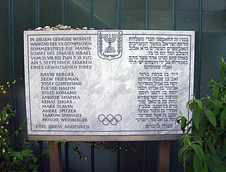Placa conmemorativa bilingüe en el edificio de la Villa Olímpica.