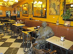 Estatua conmemorativa situada frente a un café literario histórico en Salamanca