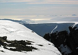 Vista al suroeste desde la cima a principios de abril con presencia de nieve y cornisas