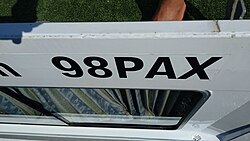 Placa informativa que detalla la capacidad máxima de pasajeros en una embarcación.