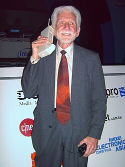Martin Cooper sosteniendo un dispositivo de radiotelefonía