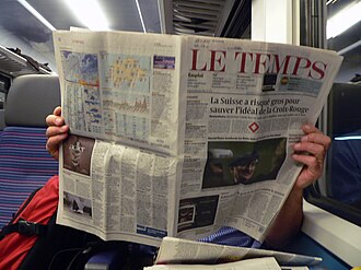 Persona leyendo el periódico Le Temps