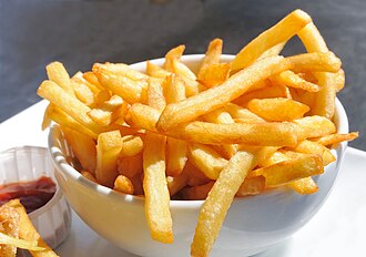 Un plato de papas o patatas fritas acompañado de kétchup.