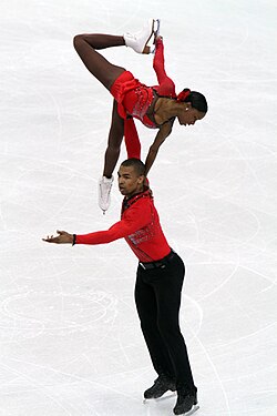 Elevación en posición de estrella durante una rutina de patinaje.