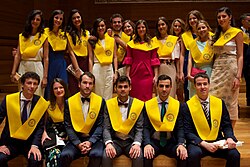 Médicos recién graduados luciendo el distintivo de la beca amarilla.
