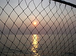 Puesta de sol en el lago Erie a través de una red de pesca