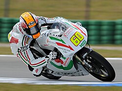 Piloto de motociclismo equipado con indumentaria y casco protector.