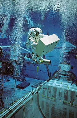 Un astronauta en el entrenamiento para una misión de la actividad extravehicular utilizando un entorno de simulación submarina.