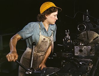 Trabajadora labrando piezas en un torno revólver para aviones en 1942