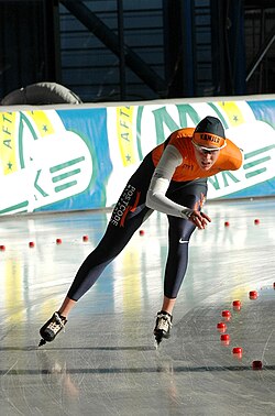 Patinadora de velocidad sobre pista de hielo.