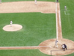 Un bate y una pelota de béisbol sobre un campo de juego.