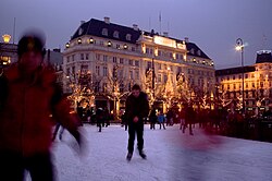 Personas patinando en la plaza durante el invierno