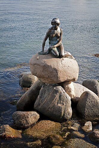 La estatua de La Sirenita sobre las rocas en la costa de Copenhague