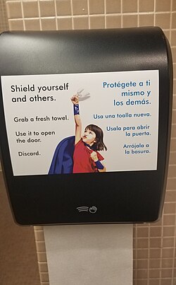 Señal bilingüe sobre la importancia de la higiene de manos en espacios públicos.