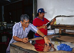 Artesanos trabajando láminas de estaño en un taller tradicional