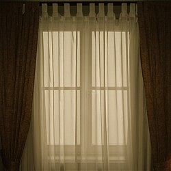 Cortinas translúcidas ligeras colgadas ante una ventana