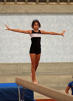 Gimnasta practicando en una viga de equilibrio
