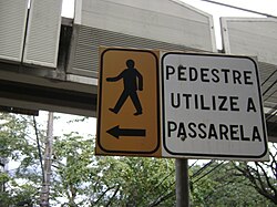 Señal en Belo Horizonte, Brasil, guiando los peatones a un puente para el cruce seguro