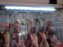 Carnes rojas en una carnicería con letreros indicativos