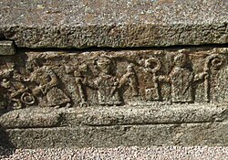 Detalle escultórico medieval en una tumba de Suecia con obispos y funcionarios.