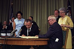 El presidente Lyndon B. Johnson firmando la creación de Medicare junto a Harry S. Truman y Bess Truman.