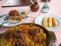 Plato de arroz atollado servido con acompañamientos