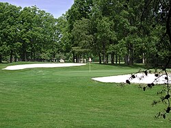 Vista de un green de golf con búnkeres y bandera