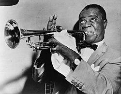 Fotografía de Louis Armstrong tocando la trompeta.