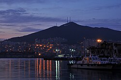Panorámica nocturna del distrito de Yeongdo-gu iluminado junto a las aguas del puerto.