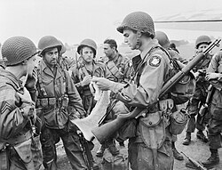 Paracaidistas aliados recibiendo instrucciones antes de abordar su avión.