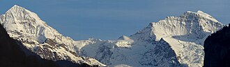 Fotografía histórica o paisajística de las cumbres del Mönch y el Jungfrau en los Alpes.