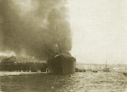 Ilustración histórica del vapor Cabo Machichaco incendiado en el muelle