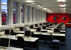 Un laboratorio de computadoras universitario que contiene varias computadoras de escritorio
