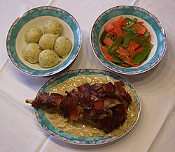 Plato de pierna de venado servido con salsa de manzana y verduras