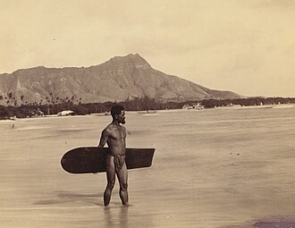 Surfista sobre tabla de madera en la playa