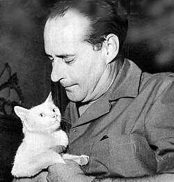 Roberto Rossellini sentado junto a una gata