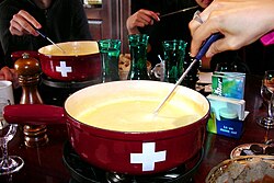 Típica fondue de queso suiza servida en un recipiente central